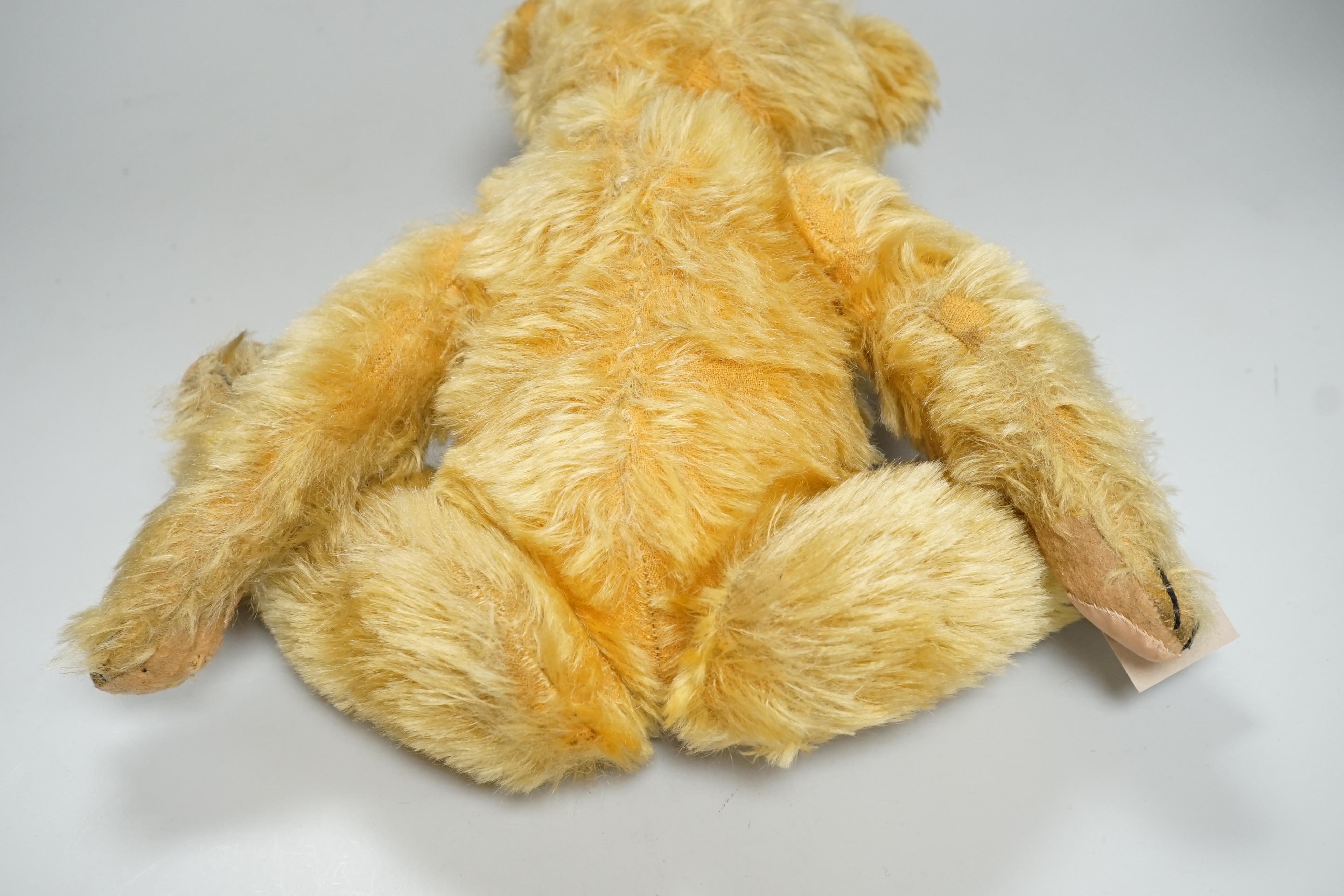 A Deans 1950's mouse eared bear, label on left foot, 16in., repair to paw pads, good mohair